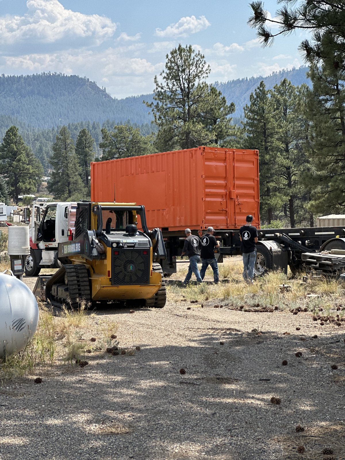 HOT BOX delivery — orange container arriving on flatbed with DEKON crew